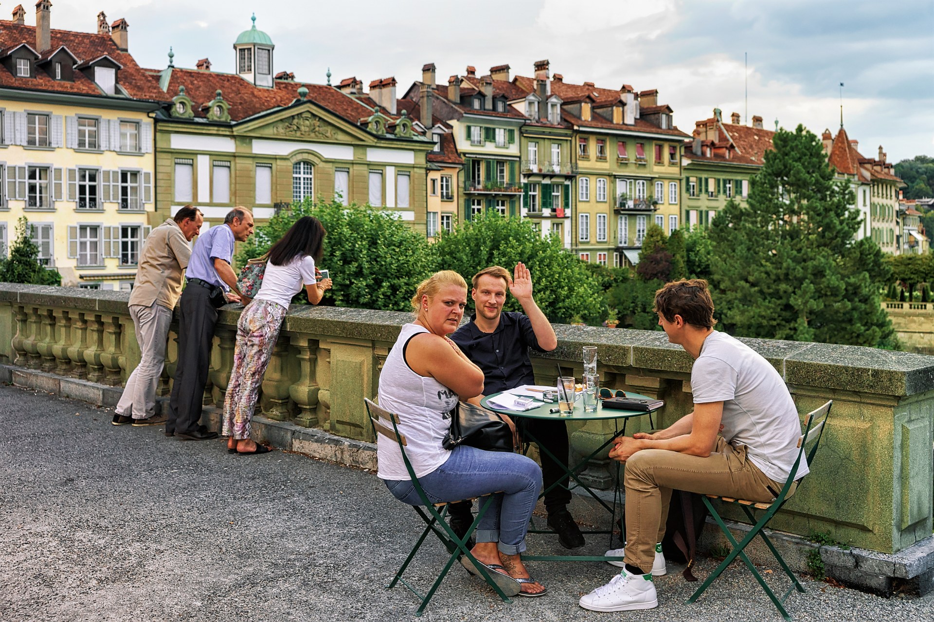 Friends at an open-air café table on the Münsterplattform terrace in Bern's old town